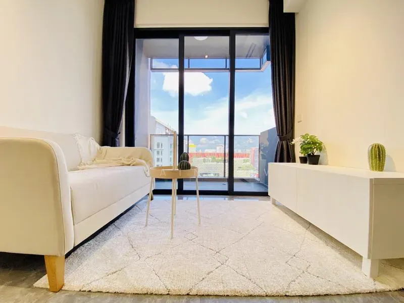 Furnished apartment living room before AI restyling, with a plain white sofa, small side table, white media console and a bright daytime view through floor-to-ceiling windows