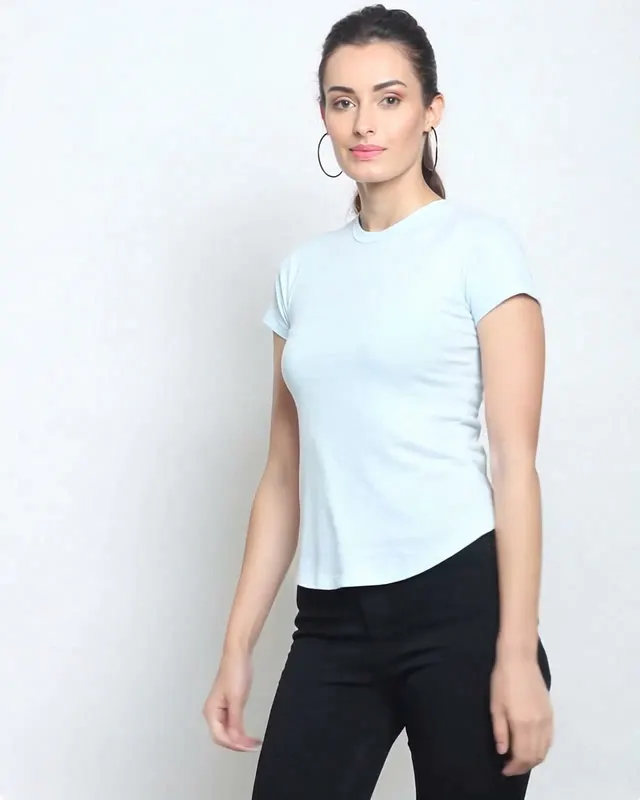 AI fashion video ad: a model in a pale blue t-shirt and black trousers on a white studio background